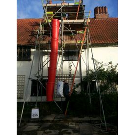 Carrying Micafil insulation up scaffolding ready to pour down around flue